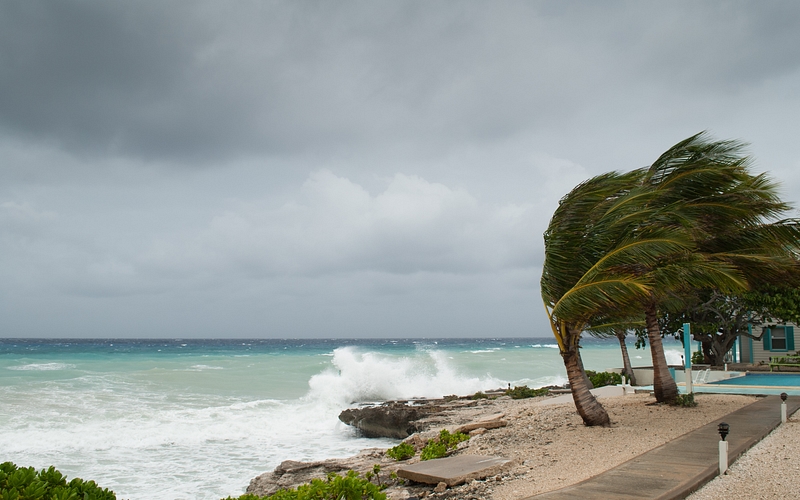 A hurricane is about to batter this caribbean beach hut The seas are raging and the skies show the tropical storm as the power of nature is demonstrated Waves crash on the shore